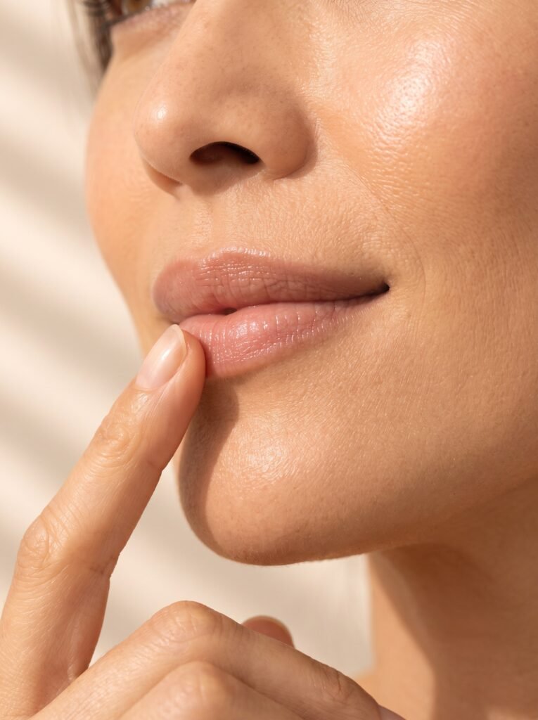 Natural lips with a soft balm sheen in warm light